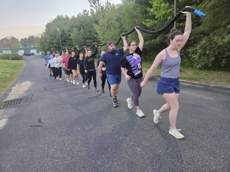 Group carrying a heavy rope down a road during a Cynergy training session